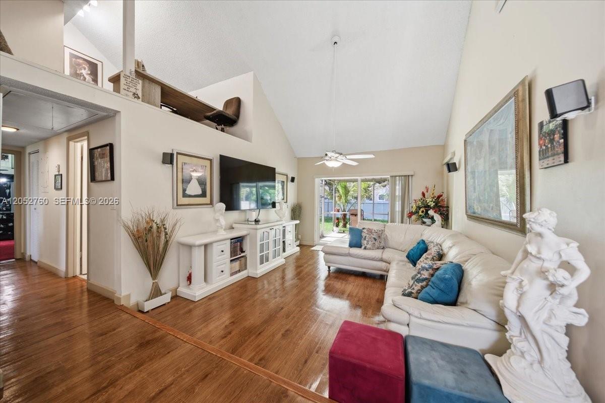 A living room features vaulted ceilings, wood flooring, a white sectional sofa, and a loft — 9050 Crescent Dr, Miramar FL 33025, MIRAMAR, FL