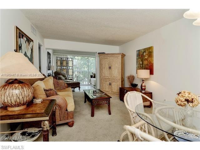 A living room features a beige sofa, a wooden coffee table, and a glass dining table — OTHER CITY - IN THE STATE OF FLORIDA, FL