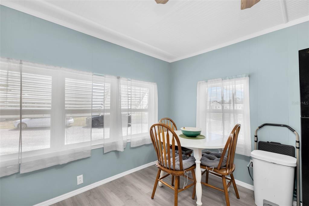 A dining area features light blue walls, wood-look flooring, and a white table with chairs — 6835 ANAPA COURT, NORTH PORT, FL