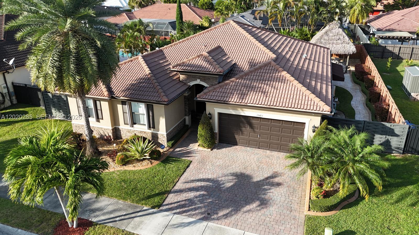 An aerial view shows a single-story house with a tiled roof, garage, and landscaped yard — 15413 SW 116th Ter, Miami FL 33196, MIAMI, FL