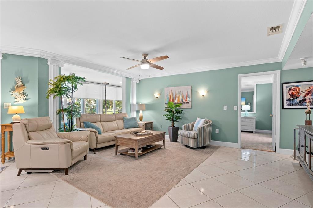A living room features light green walls, a beige sofa, and a tiled floor — 6101 34TH STREET W UNIT 2B, BRADENTON, FL