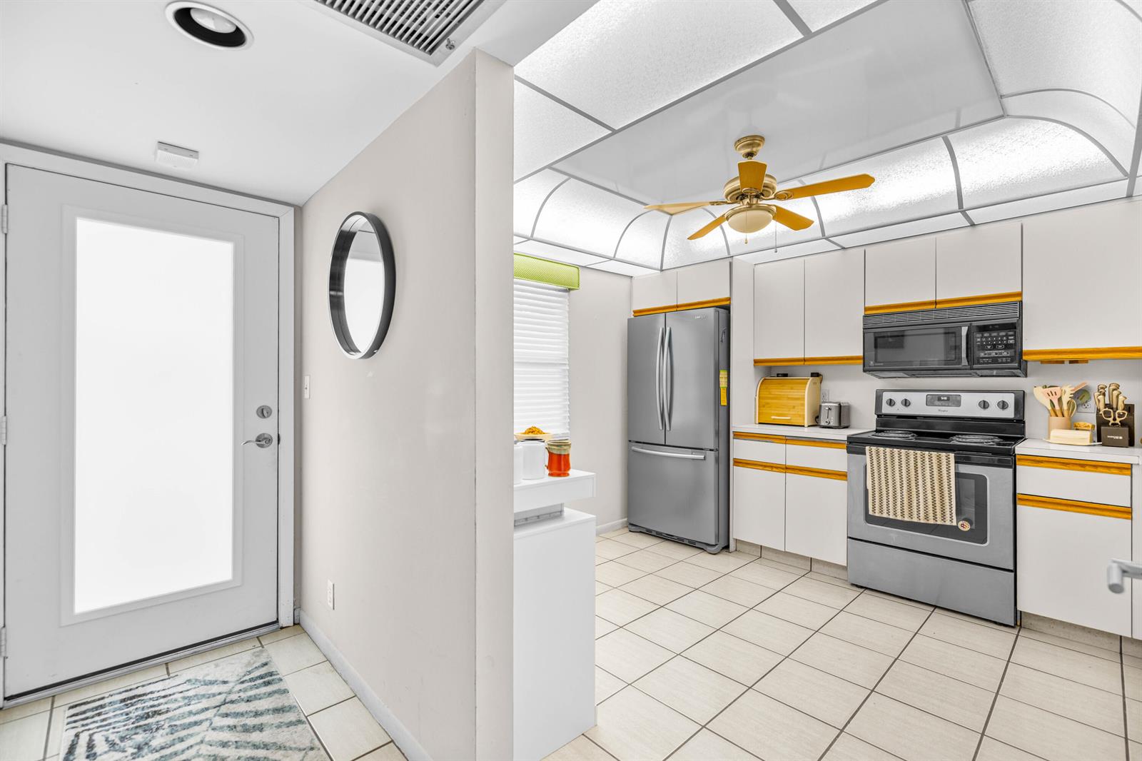 A kitchen with white cabinets, stainless steel appliances, and a ceiling fan with light panels — 3301 Aruba Way # D3, Coconut Creek FL 33066, COCONUT CREEK, FL