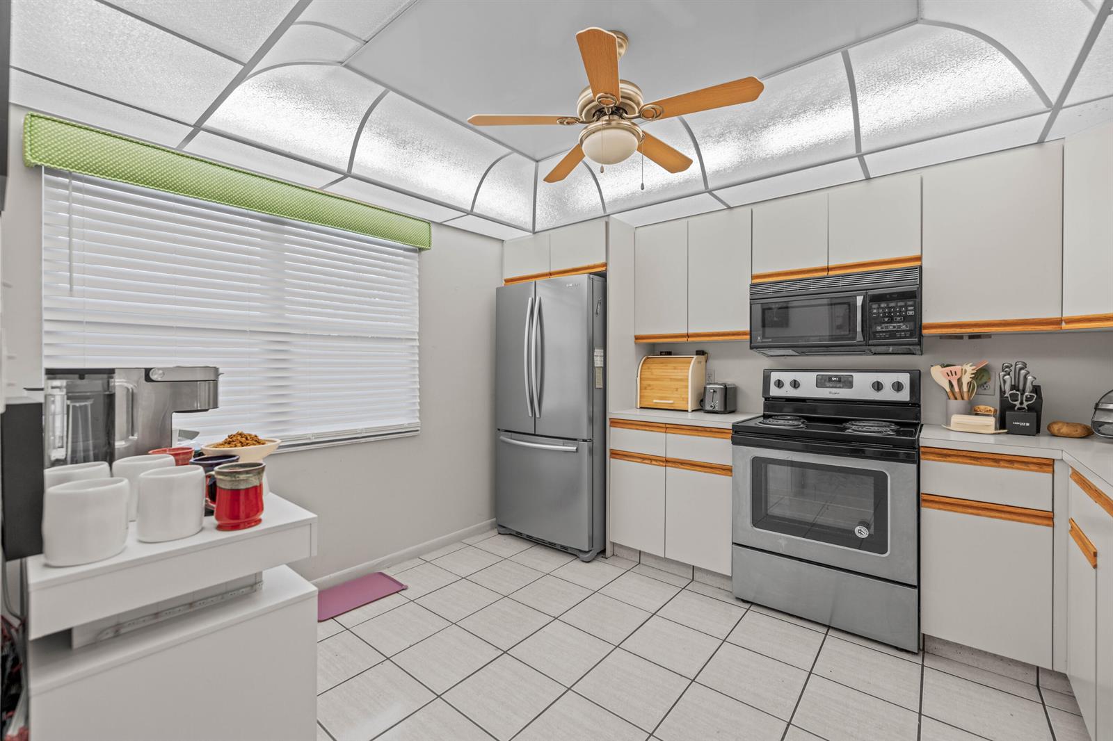 A kitchen features white cabinets, stainless steel appliances, a tiled floor, and a ceiling fan — 3301 Aruba Way # D3, Coconut Creek FL 33066, COCONUT CREEK, FL