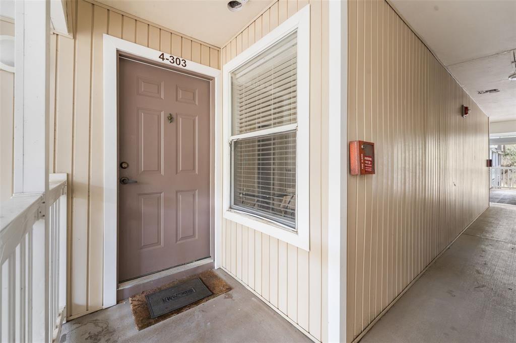 An exterior view of an apartment entrance with a brown door labeled 4-303 — 4000 SW 23RD STREET UNIT 4-303, GAINESVILLE, FL