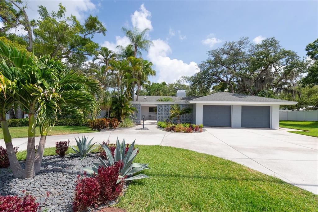 A single-story house with a two-car garage, concrete driveway, and decorative breeze block wall — 1350 FAIRWAY DRIVE, DUNEDIN, FL