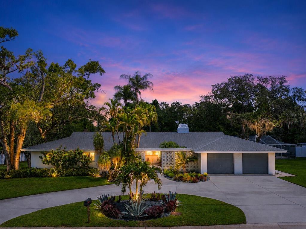 A single-story house with a two-car garage and palm trees at dusk — 1350 FAIRWAY DRIVE, DUNEDIN, FL