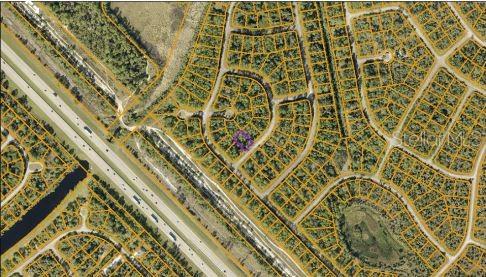 This aerial map shows a residential neighborhood with a highlighted vacant lot — JUBILEE CIRCLE, NORTH PORT, FL