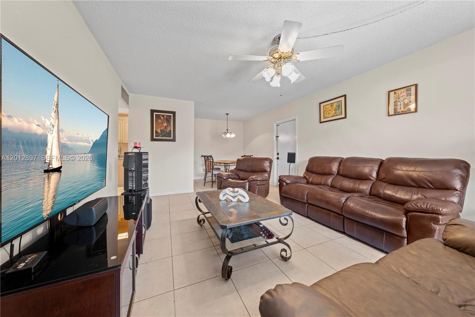 A living room features a large television, brown leather furniture, and tile flooring — 7829 Miller Dr # B205, Miami FL 33155, MIAMI, FL