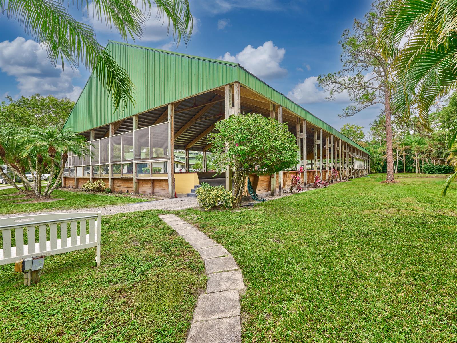 A paved walkway leads to the entrance of a single-story house with palm trees — 18238 128th Trail N, Jupiter FL 33478, JUPITER, FL
