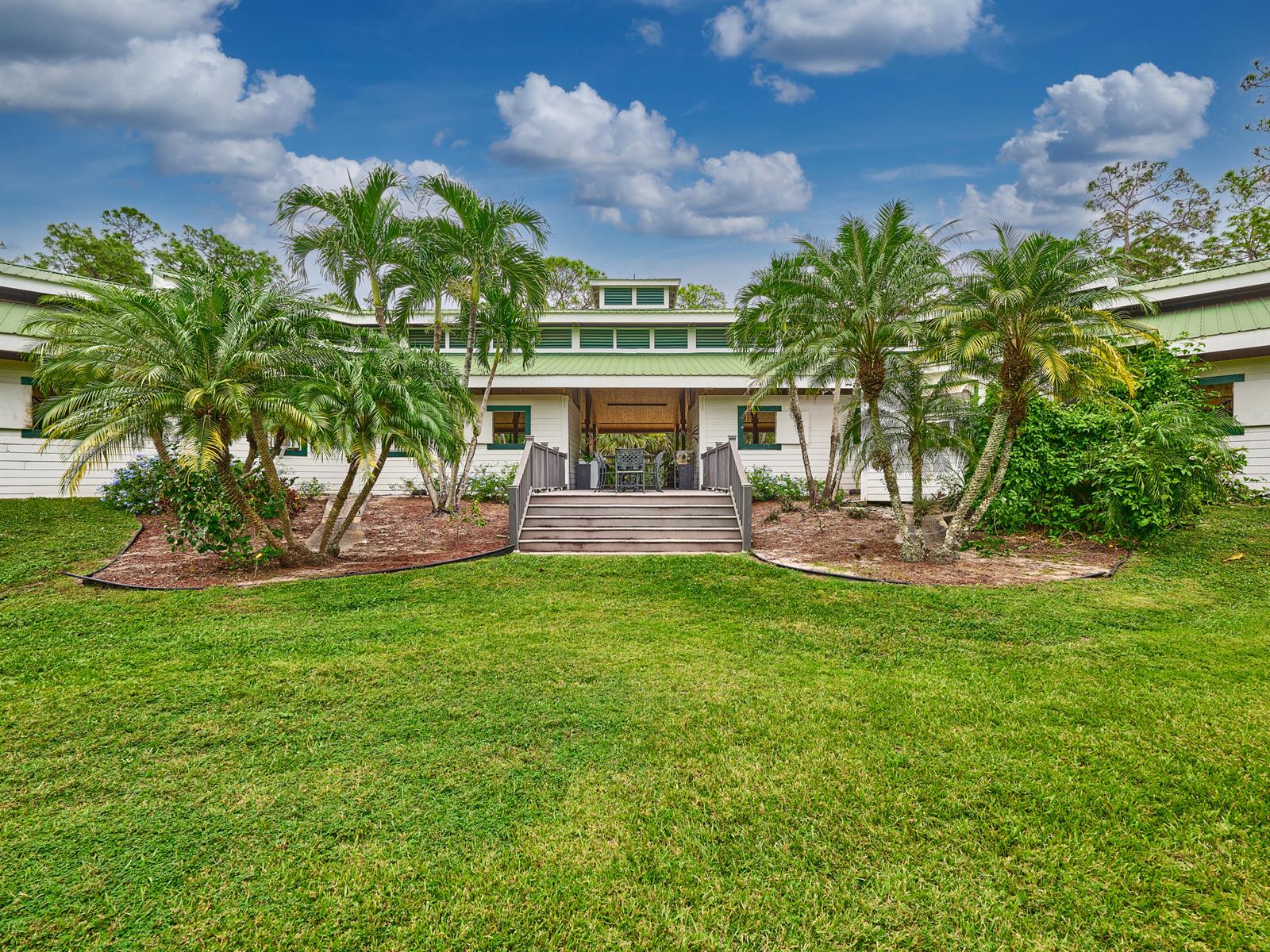 An entryway with double glass doors leads into a living area with vaulted wood-beamed ceilings — 18238 128th Trail N, Jupiter FL 33478, JUPITER, FL