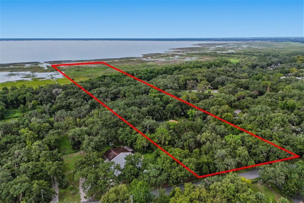 An aerial view shows a rectangular property outlined in red extending toward a large lake — 2794 HOLIDAY WOODS DRIVE, KISSIMMEE, FL