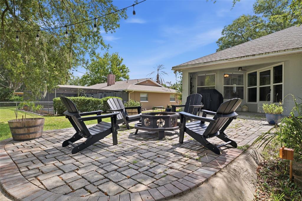 A paved patio features four Adirondack chairs arranged around a metal fire pit — 240 N COUNTRY CLUB DRIVE, CRYSTAL RIVER, FL
