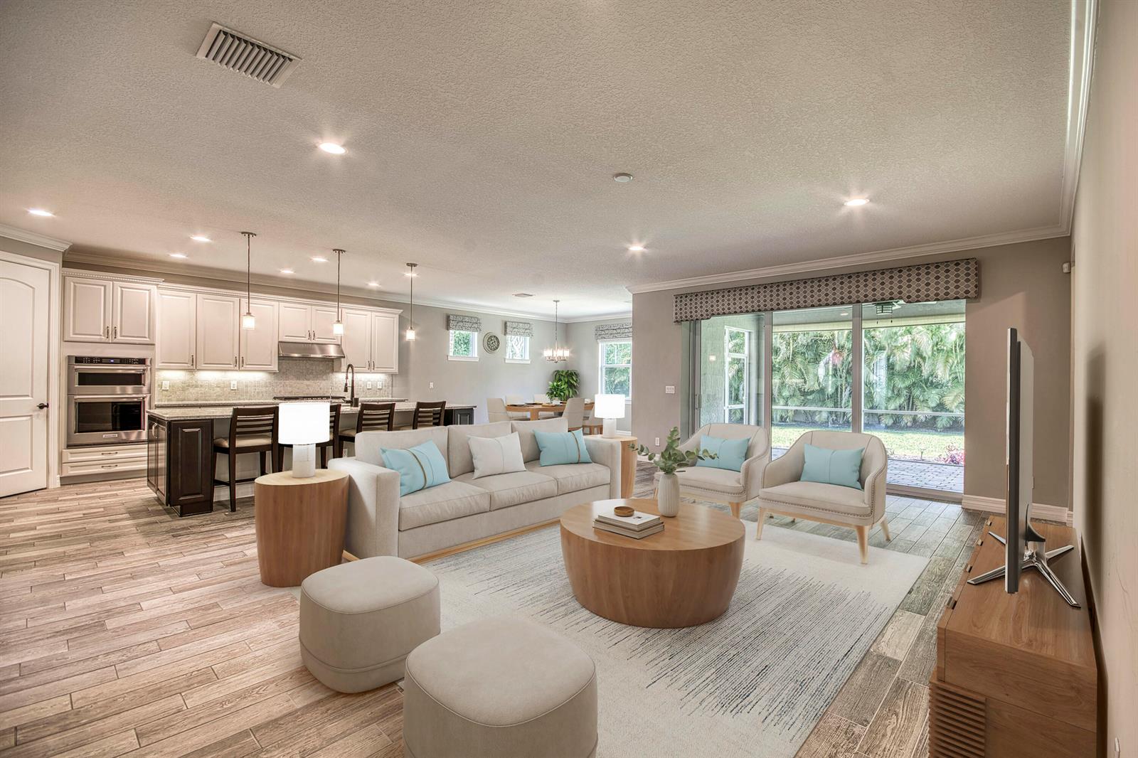 An open-concept living room and kitchen featuring light wood-look tile flooring and sliding glass doors — 134 Shores Pointe Drive, Jupiter FL 33458, JUPITER, FL