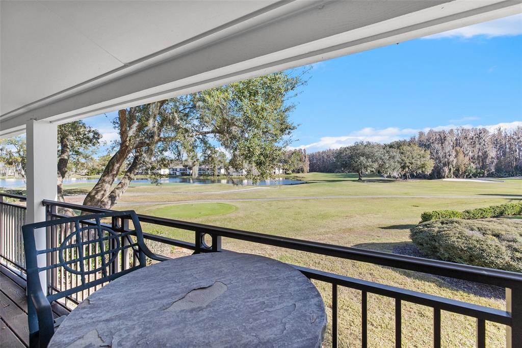 A paved walkway leads to the entrance of a two-story apartment building with palm trees — 4744 FOX HUNT DRIVE UNIT 1022 & 1024, WESLEY CHAPEL, FL