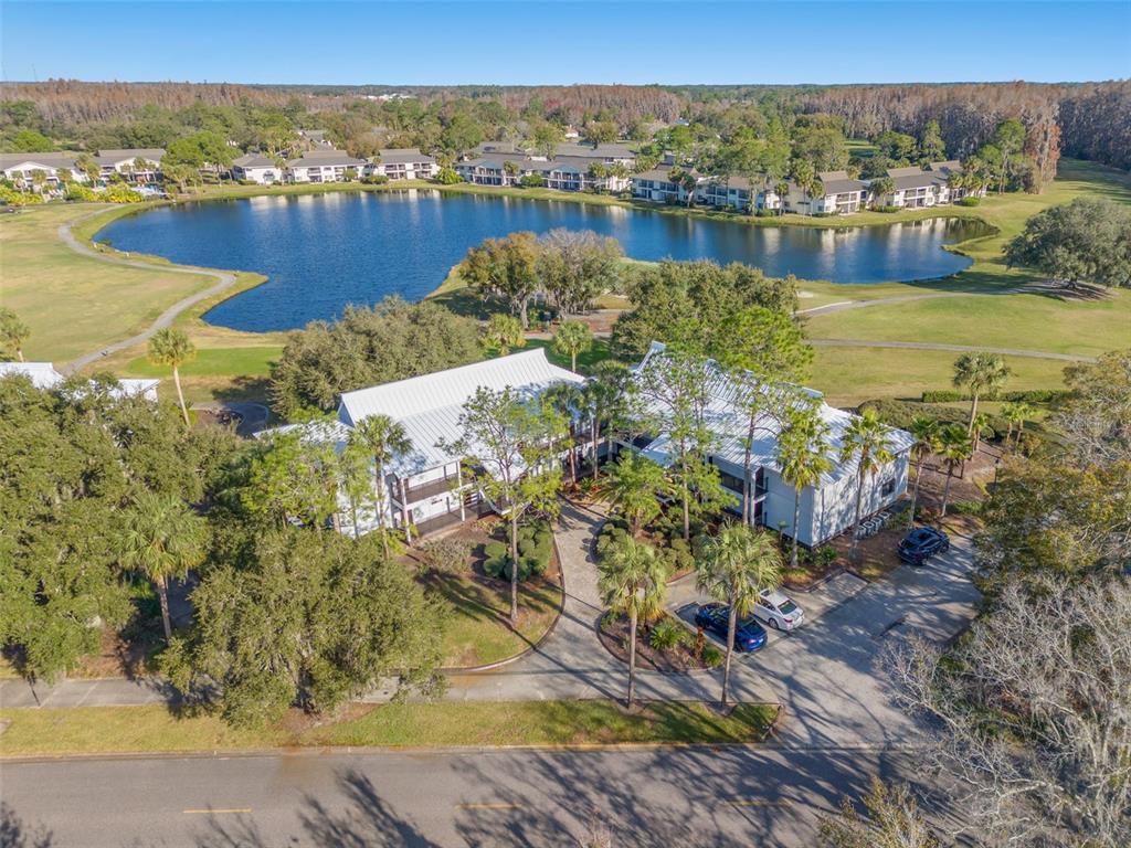 A balcony with a stone table overlooks a golf course and a pond — 4744 FOX HUNT DRIVE UNIT 1022 & 1024, WESLEY CHAPEL, FL