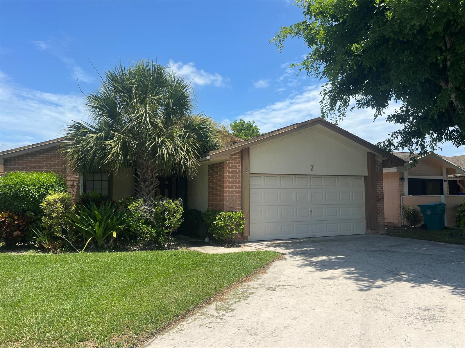 A single-story brick and stucco house features a two-car garage and a front yard — 7 Islington Place, Boynton Beach FL 33426, BOYNTON BEACH, FL