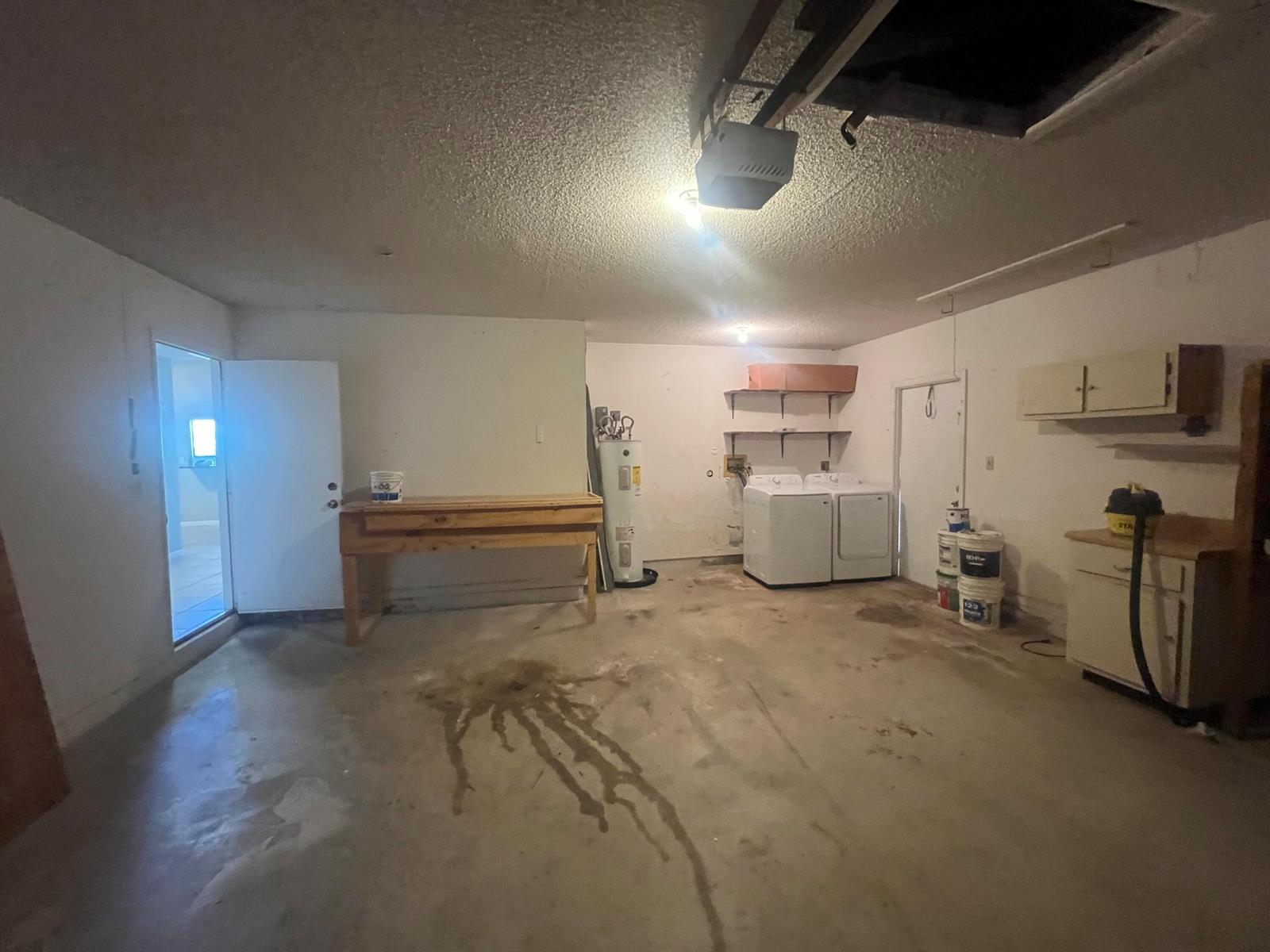 A garage features a concrete floor, a workbench, a water heater, and a laundry area — 7 Islington Place, Boynton Beach FL 33426, BOYNTON BEACH, FL