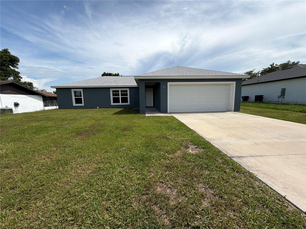 A single-story house with a gray exterior, a two-car garage, and a concrete driveway — 4004 SW 138TH PLACE, OCALA, FL