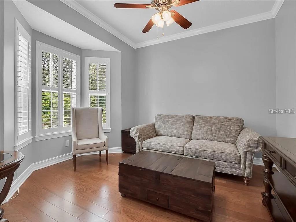 A living room features light gray walls, hardwood floors, a sofa, and a bay window — 2660 WINNEMISSETT OAKS DRIVE, DELAND, FL