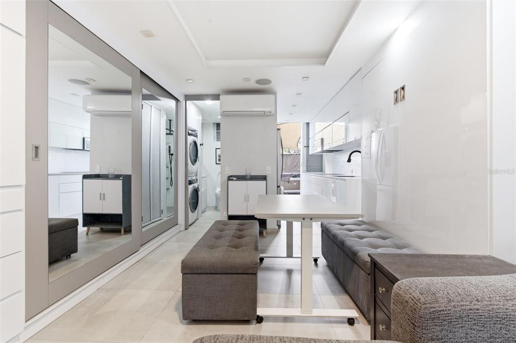 A modern, narrow room features a dining area with two benches, a kitchen, and laundry — 1477 ASHFORD AVENUE UNIT 9A, SAN JUAN, PR