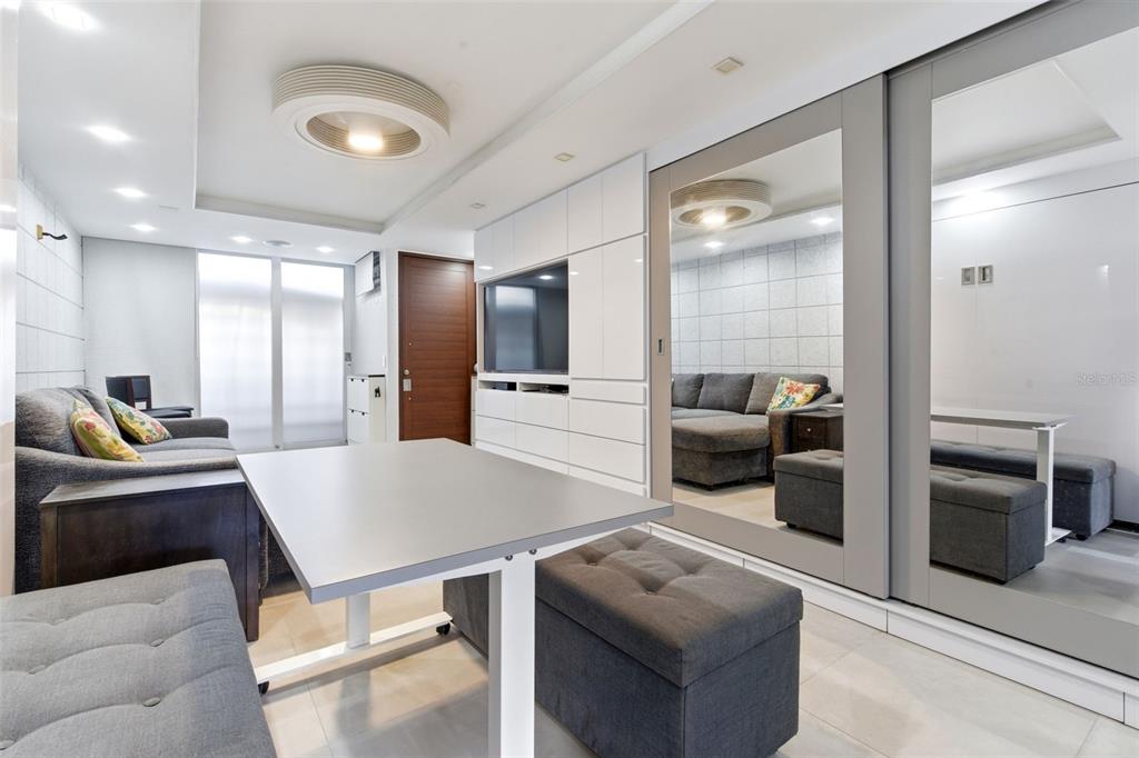 A modern living room features a gray sofa, a dining table, and large mirrored closet doors — 1477 ASHFORD AVENUE UNIT 9A, SAN JUAN, PR
