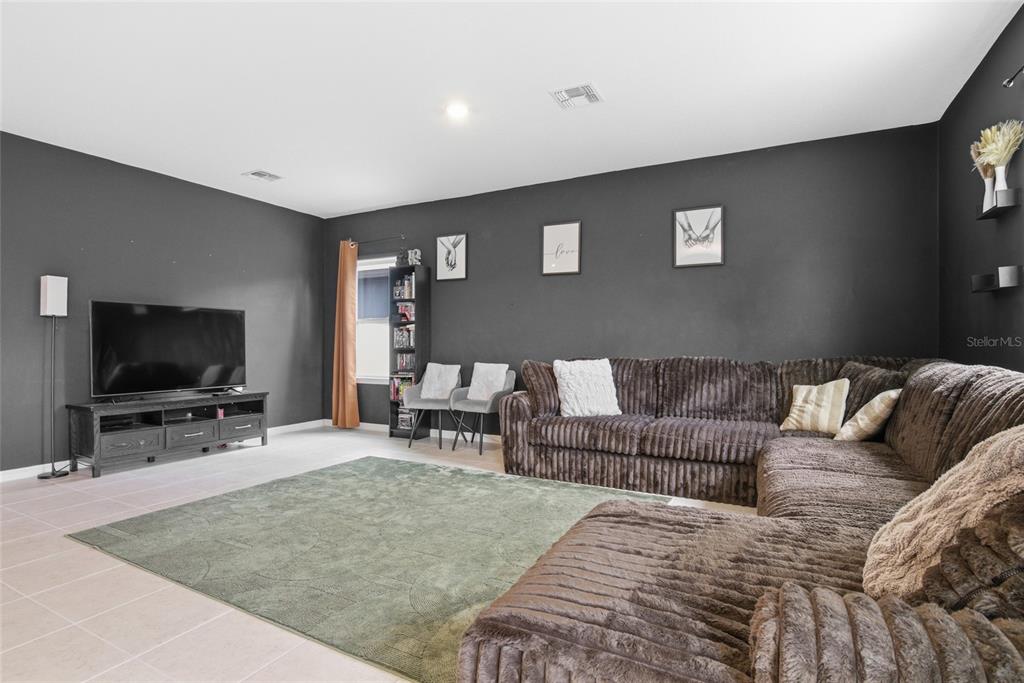 A living room features dark gray walls, a large brown sectional sofa, and a green rug — 2004 BUCKHANON TRL, DELAND, FL
