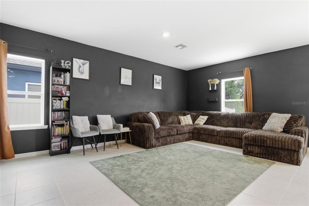 A living room features dark gray walls, a large brown sectional sofa, and a rug — 2004 BUCKHANON TRL, DELAND, FL