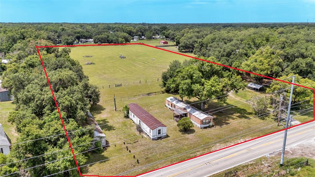 An aerial view shows a large grassy lot with three mobile homes near a road — 3146 MOUNT TABOR ROAD, LAKELAND, FL