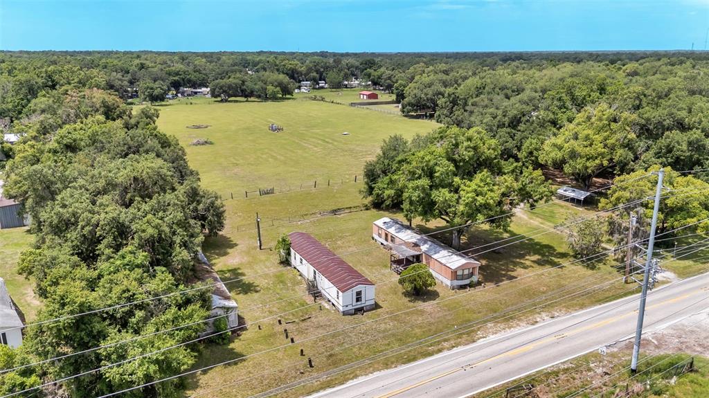 An aerial view shows two mobile homes situated on a large, grassy lot near trees — 3146 MOUNT TABOR ROAD, LAKELAND, FL
