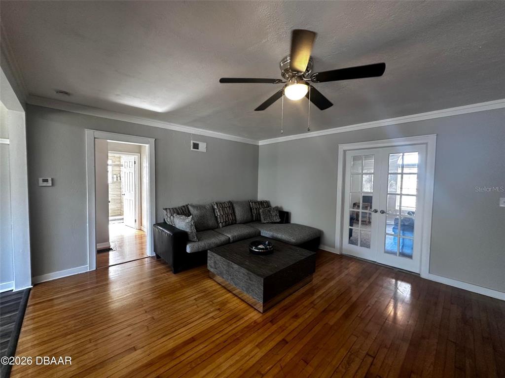 A living room features a grey sectional sofa, a coffee table, and hardwood floors — 1711 OCEAN DUNES TERRACE, DAYTONA BEACH, FL