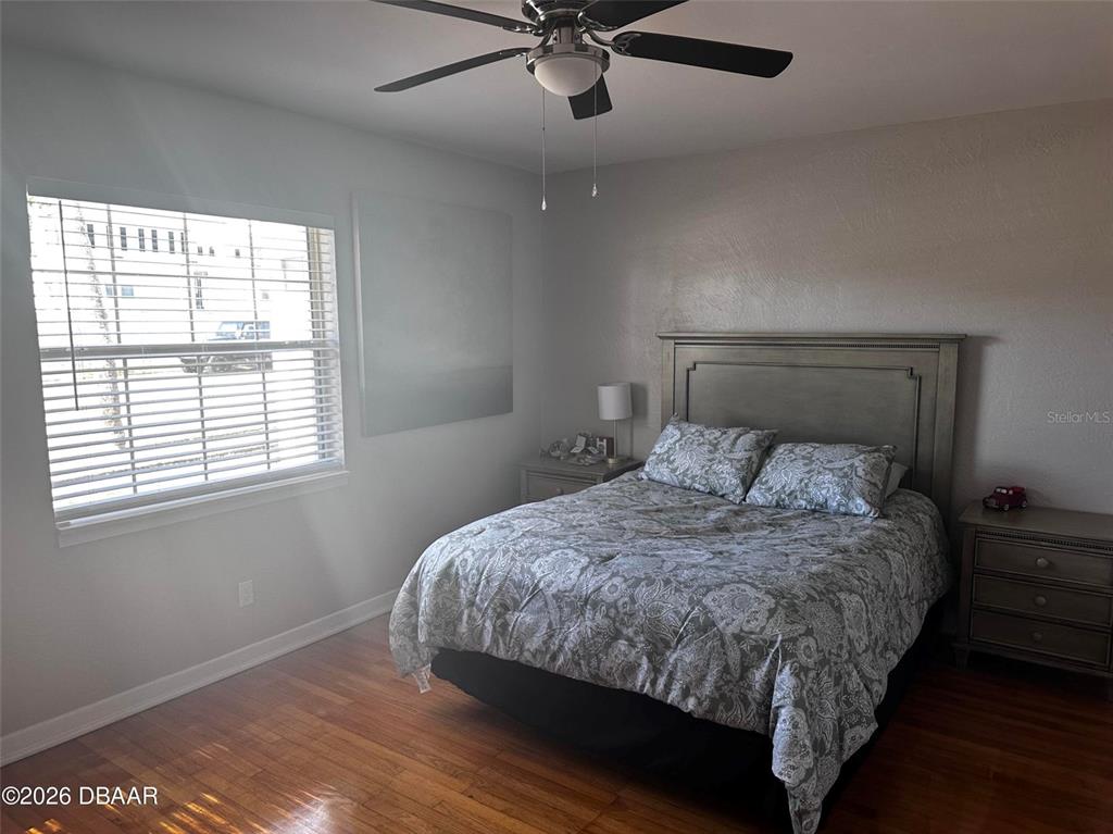 A bedroom features a bed with patterned bedding, a ceiling fan, and a window — 1711 OCEAN DUNES TERRACE, DAYTONA BEACH, FL