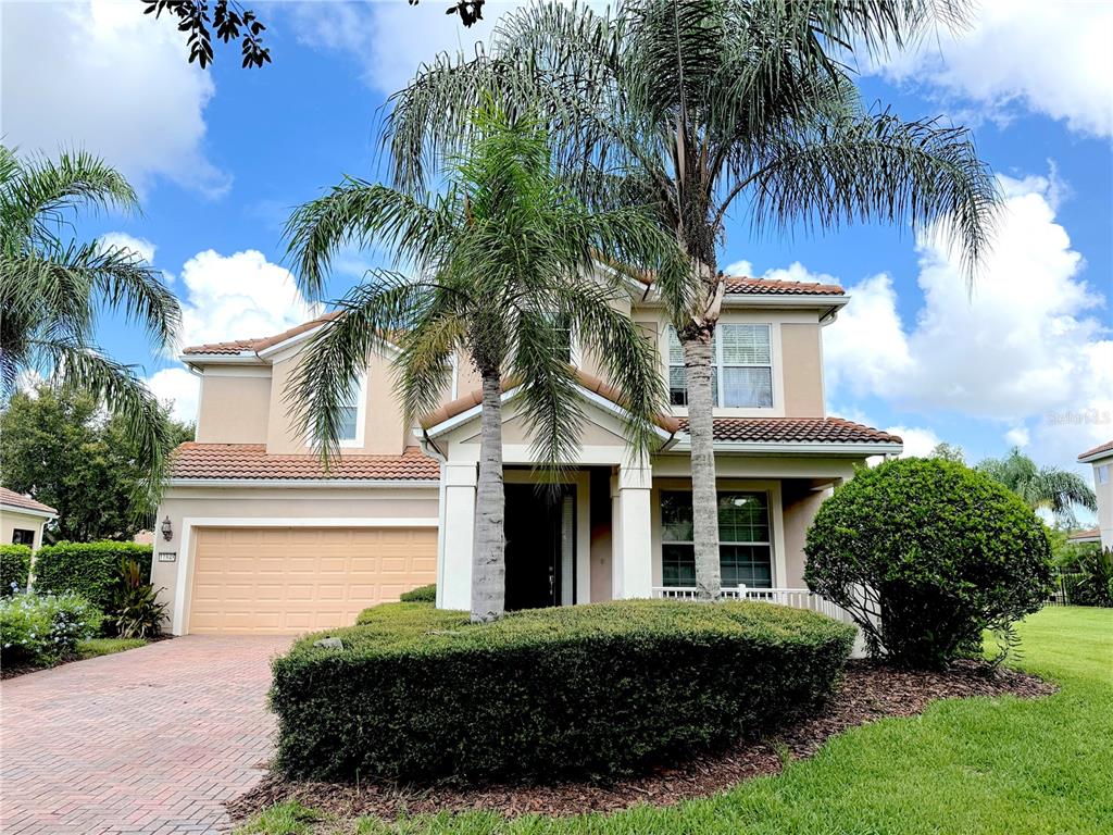 A two-story suburban house with a tile roof, palm trees, and a paved driveway — 11848 ZELKOVA LANE, ORLANDO, FL