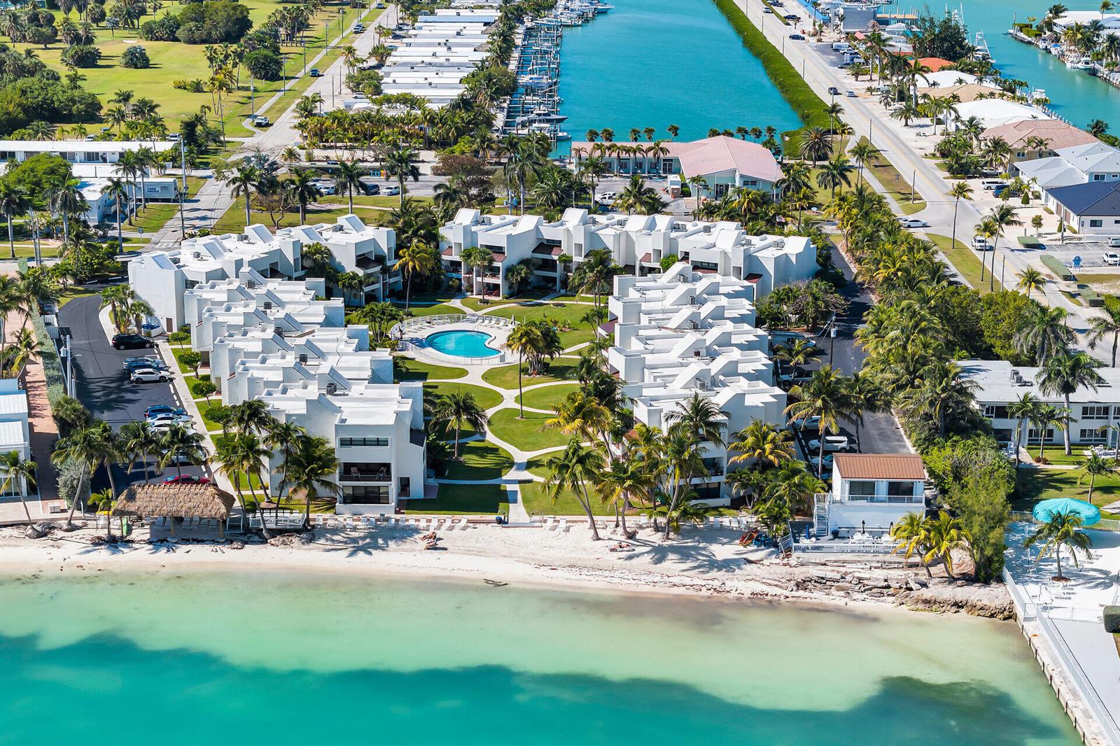 Aerial view of a beachfront condominium complex with a central pool and landscaped courtyard — 601 W Ocean Dr Drive # 203a, FL 33051, FL