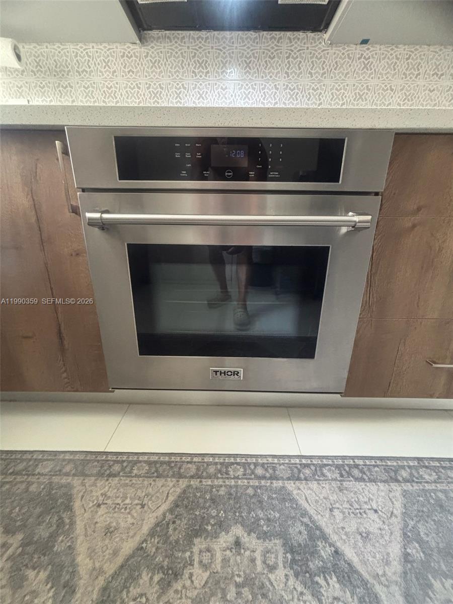 A stainless steel Thor wall oven is installed in a kitchen with wood-toned cabinets — 1865 S Ocean Dr # 4F, Hallandale Beach FL 33009, HALLANDALE BEACH, FL