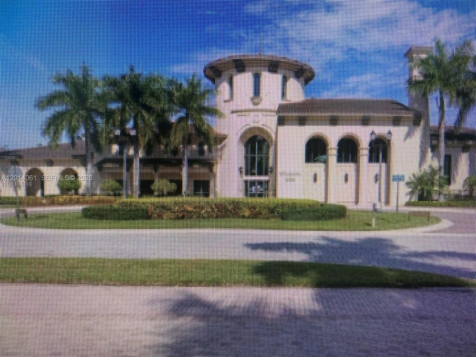 A large, multi-story Mediterranean-style building features a central tower, arched windows, and surrounding palm trees — 2955 NW 126th Ave # 5, Sunrise FL 33323, SUNRISE, FL