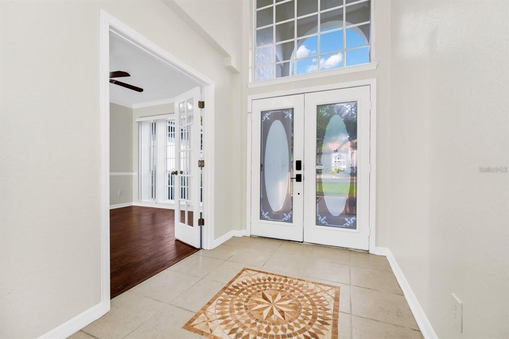 An entryway features a tiled floor with a decorative medallion, double front doors, and French doors — 3170 ZAHARIAS DRIVE, ORLANDO, FL