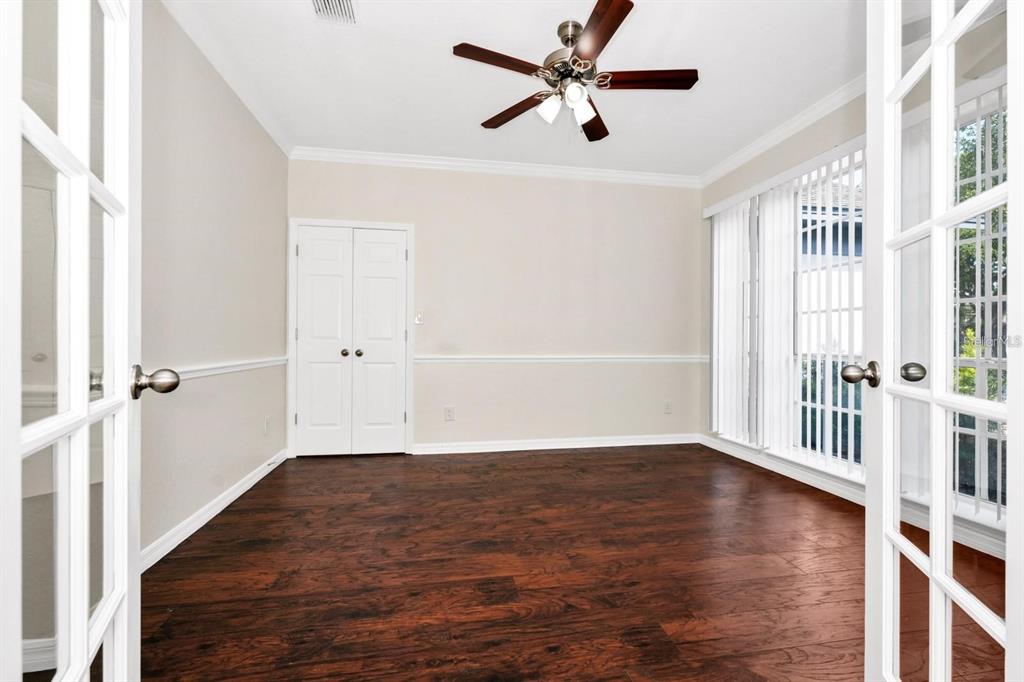 A room with dark wood flooring, a ceiling fan, white walls, and French doors — 3170 ZAHARIAS DRIVE, ORLANDO, FL