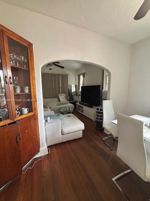 A dining area with a wooden cabinet leads through an arched doorway into a living room — 2643 NW 23rd Ct, Miami FL 33142, MIAMI, FL
