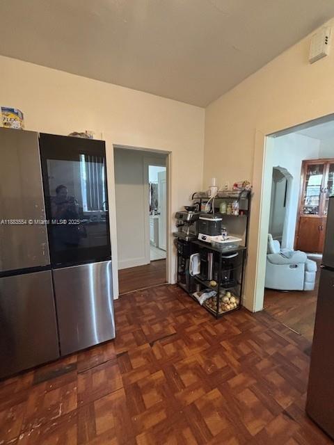 A kitchen features a stainless steel refrigerator, a metal shelving unit, and parquet wood flooring — 2643 NW 23rd Ct, Miami FL 33142, MIAMI, FL
