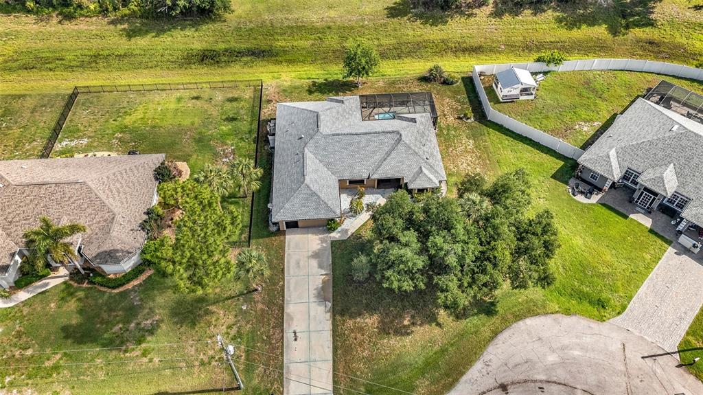 An aerial view shows a suburban house with a pool cage and a long driveway — 2338 KELSEY COURT, NORTH PORT, FL