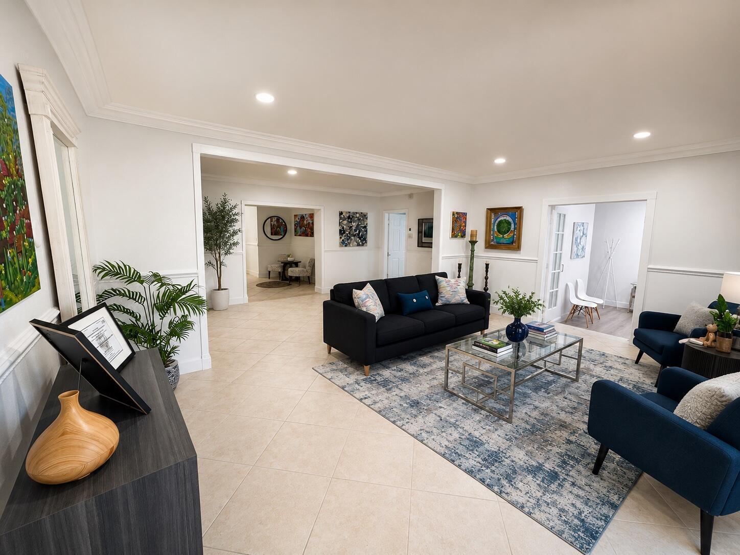A living room features a black sofa, blue armchairs, a glass coffee table, and tile flooring — 150 NE 146th Street NE, Miami FL 33161, MIAMI, FL