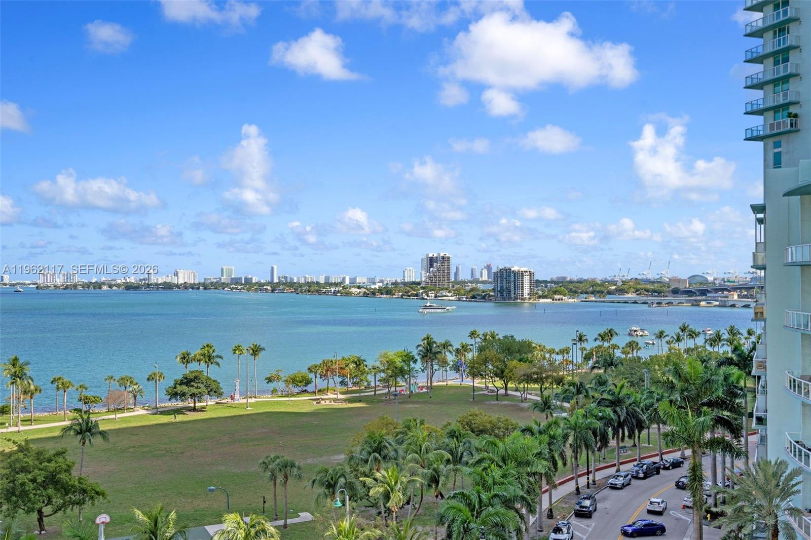 An elevated view of a coastal park, bay, and city skyline from a balcony — 2000 N Bayshore Dr # 909, Miami FL 33137, MIAMI, FL
