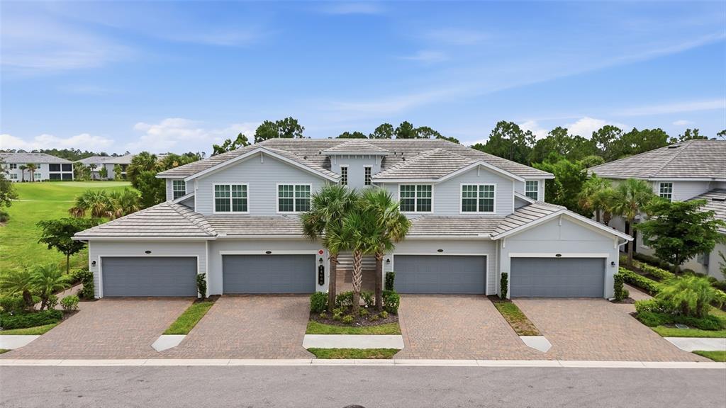 An exterior view of a two-story residential building with four garage doors and paved driveways — 14680 SYCAMORE COURT UNIT 3712, PUNTA GORDA, FL