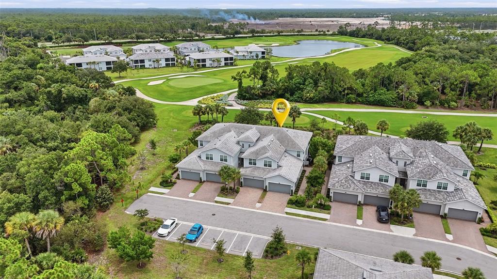 An aerial view shows two multi-unit residential buildings situated next to a golf course — 14680 SYCAMORE COURT UNIT 3712, PUNTA GORDA, FL