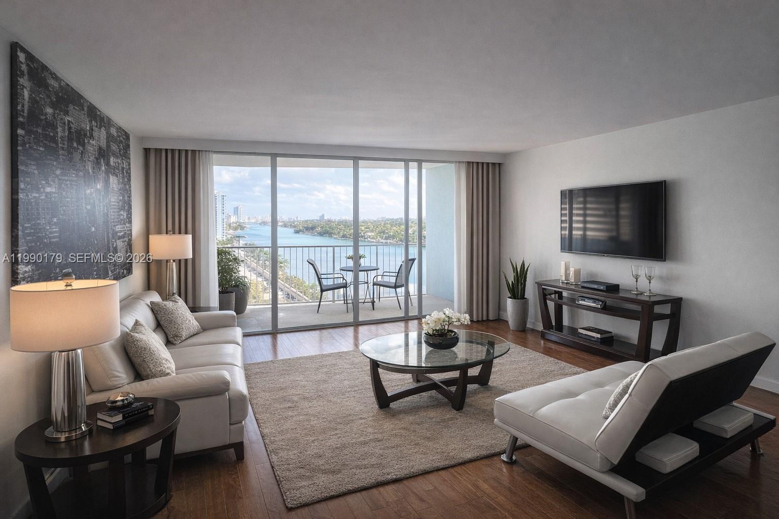 A living room features white sofas, a glass coffee table, and a balcony overlooking water — 5838 Collins Ave # 7G, Miami Beach FL 33140, MIAMI BEACH, FL