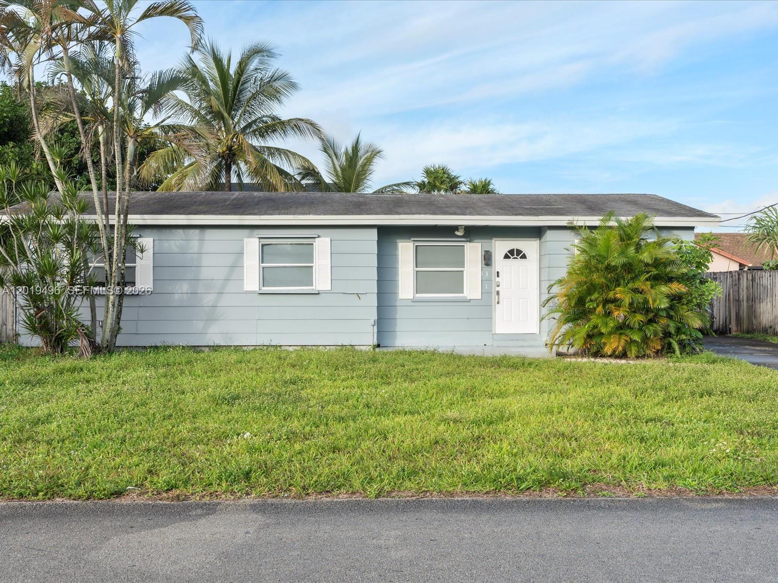 A single-story light blue house with a white door and palm trees in the yard — 5731 SW 54th Ter, Davie FL 33314, DAVIE, FL