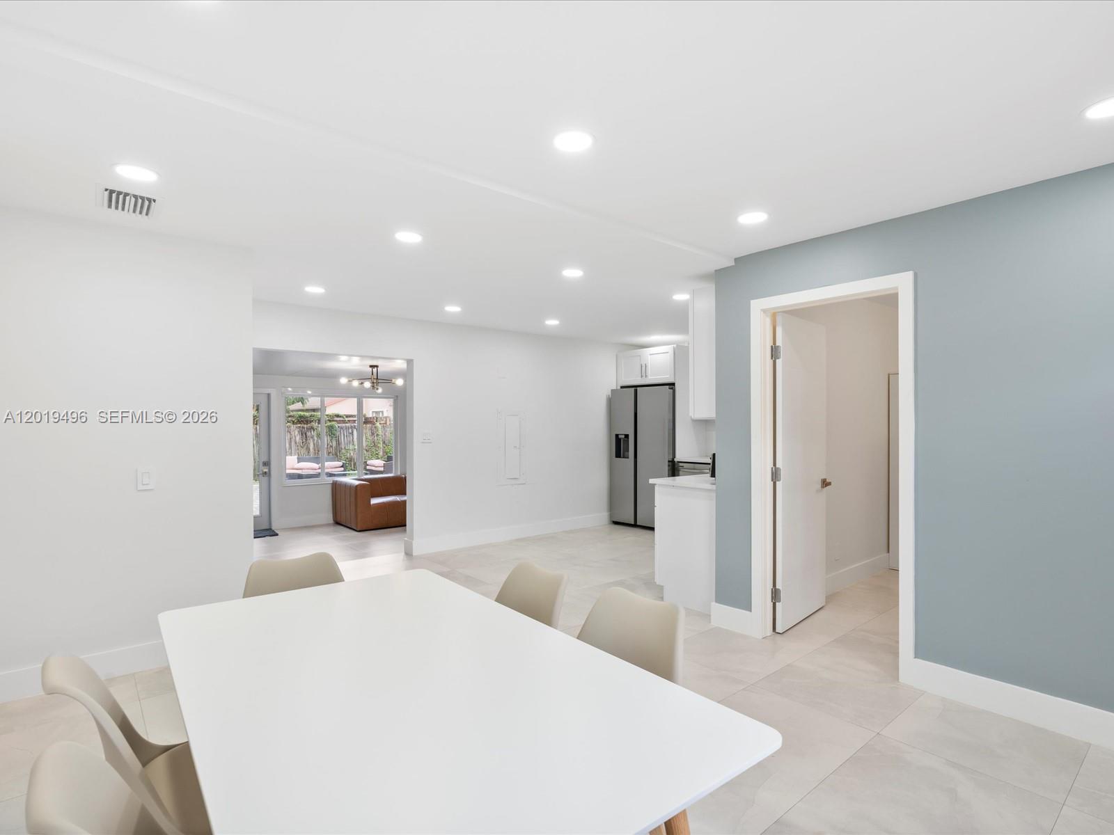 A dining area with a white table leads to a kitchen and a living space — 5731 SW 54th Ter, Davie FL 33314, DAVIE, FL
