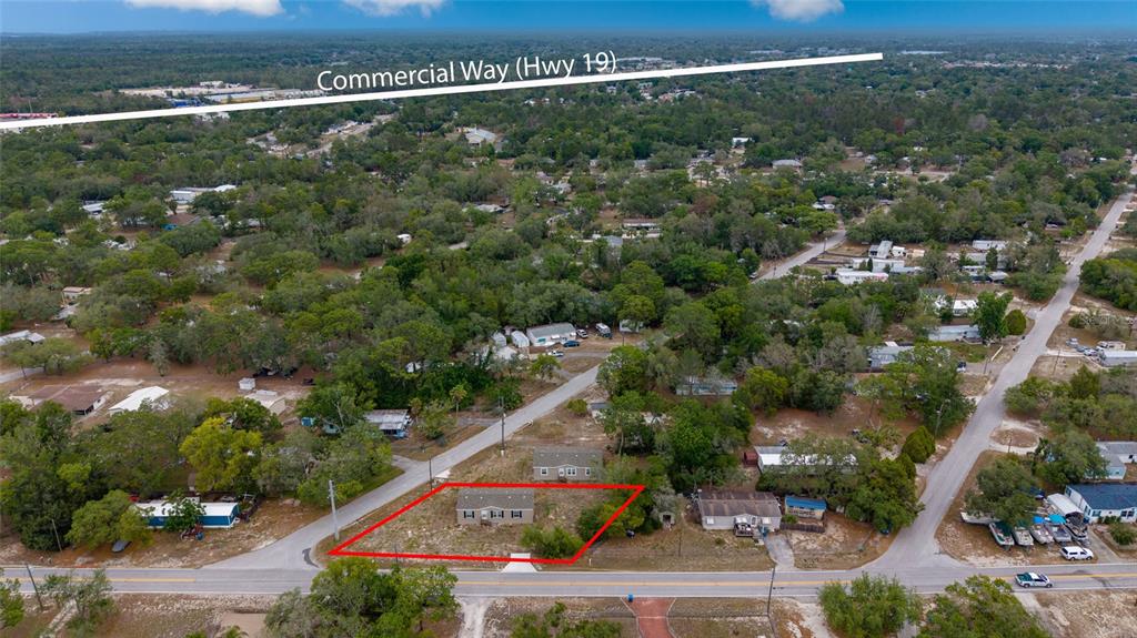An aerial view shows a single-story house outlined in red on a wooded residential lot — 7193 SEALAWN DRIVE, SPRING HILL, FL
