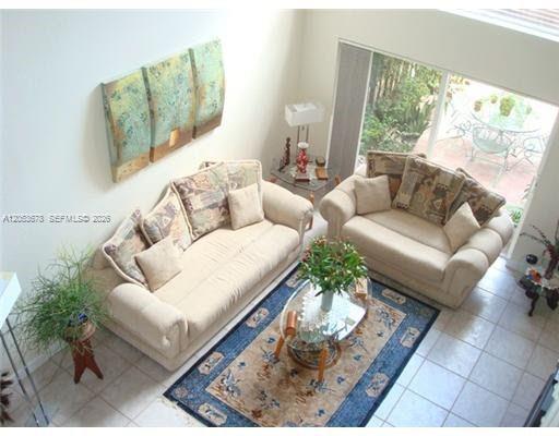 A high-angle view of a living room featuring two beige sofas and a patterned rug — 5273 NW 113th Ave, Doral FL 33178, DORAL, FL