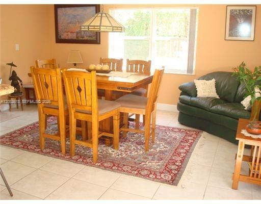 A dining area features a wooden table with four chairs on a patterned area rug — 5273 NW 113th Ave, Doral FL 33178, DORAL, FL